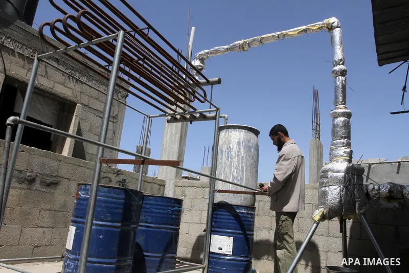 Palestinian Mahmoud Soboh, 28, works on a machine to extract fuel from plastic at a workshop in his house in Nuseirat refugee camp, central Gaza Strip, April 9, 2014. Soboh succeeded in production of fuel oil by the ther...