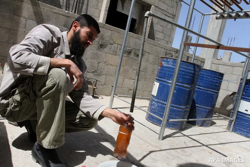Palestinian Mahmoud Soboh, 28, fills a bottle with fuel oil extracted from plastic at a workshop in his house in Nuseirat refugee camp, central Gaza Strip, April 9, 2014. Soboh succeeded in production of fuel oil by the...