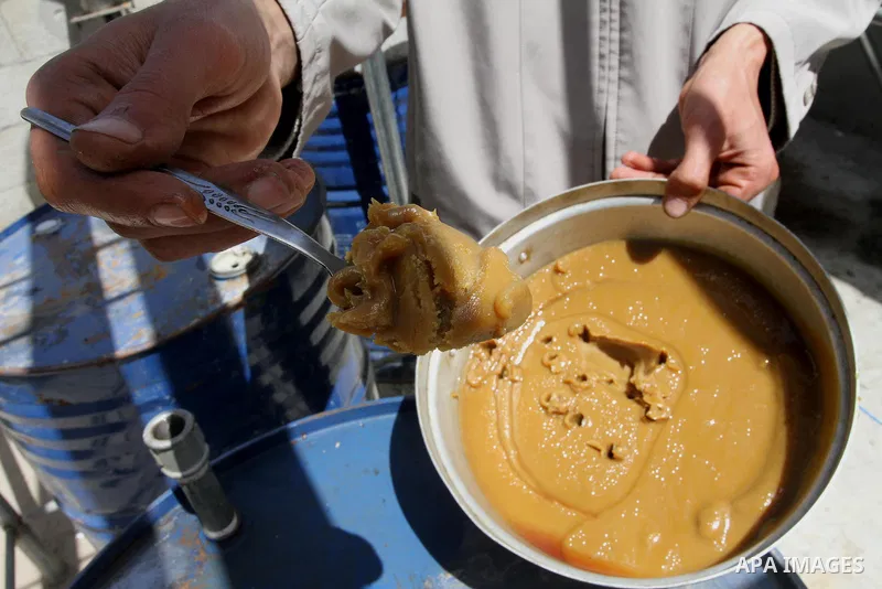 Palestinian Mahmoud Soboh, 28, displays grease oil extracted from plastic at a workshop in his house in Nuseirat refugee camp, central Gaza Strip, April 9, 2014. Soboh succeeded in production of fuel oil by the thermal a...
