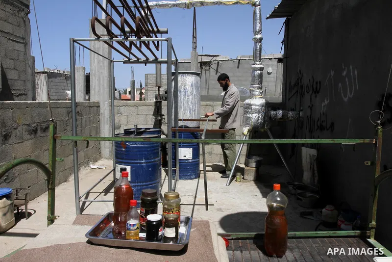 Palestinian Mahmoud Soboh, 28, works on a machine to extract fuel from plastic at a workshop in his house in Nuseirat refugee camp, central Gaza Strip, April 9, 2014. Soboh succeeded in production of fuel oil by the ther...