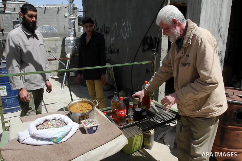 Palestinian Ibrahim Soboh, 54, works with his sons on a machine to extract fuel from plastic at a workshop in his house in Nuseirat refugee camp, central Gaza Strip, April 9, 2014. Soboh succeeded in production of fuel o...