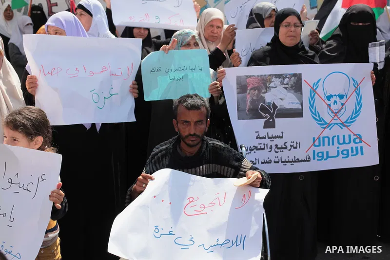 Palestinian women take part in a protest against the decision made by the United Nations Relief and Works Agency (UNRWA) to reduce food aid delivered to the Gaza Strip in front of the UNRWA headquarters in Gaza City on A...