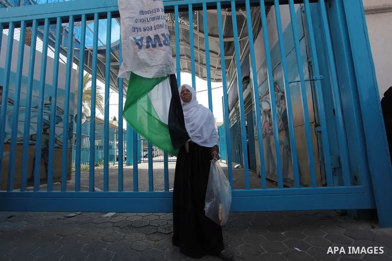 A Palestinian woman holds a sack of flour during a protest a the decision made by the United Nations Relief and Works Agency (UNRWA) to reduce food aid delivered to the Gaza Strip in front of the UNRWA headquarters in Ga...