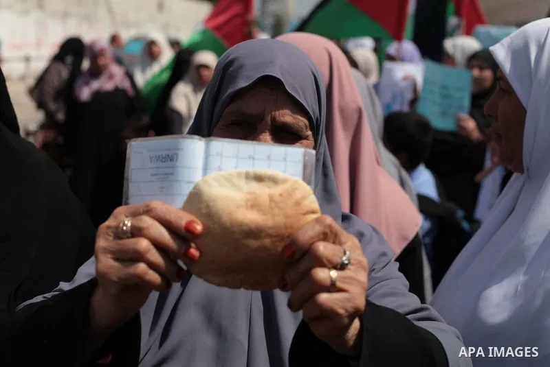 Palestinian women take part in a protest against the decision made by the United Nations Relief and Works Agency (UNRWA) to reduce food aid delivered to the Gaza Strip in front of the UNRWA headquarters in Gaza City on A...