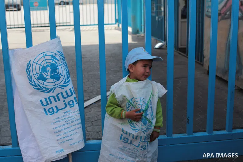 A Palestinian boy wears a sack of flour during a protest a the decision made by the United Nations Relief and Works Agency (UNRWA) to reduce food aid delivered to the Gaza Strip in front of the UNRWA headquarters in Gaza...