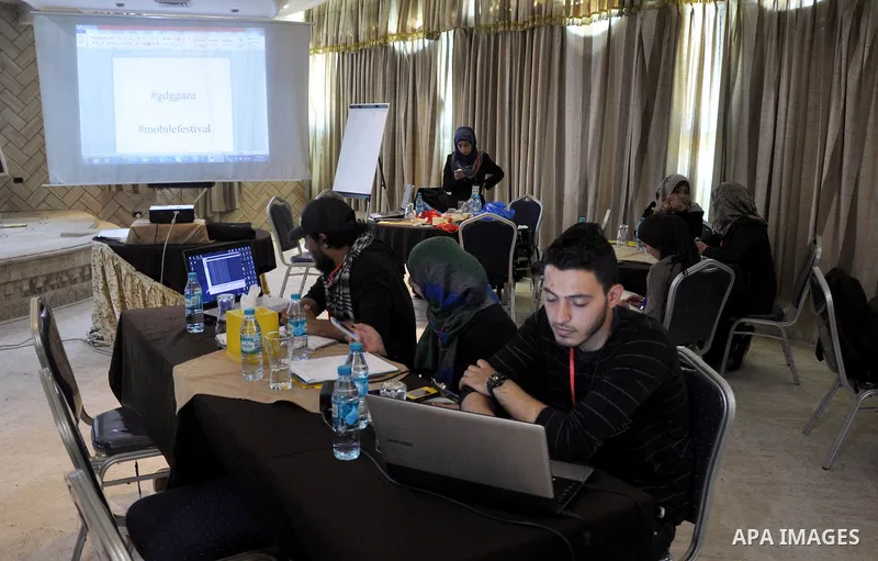 Palestinian students attend a conference of developing applications for smart phones that are running under Android operating system, in Gaza City on April 04, 2014. Students display during the meeting which was organize...
