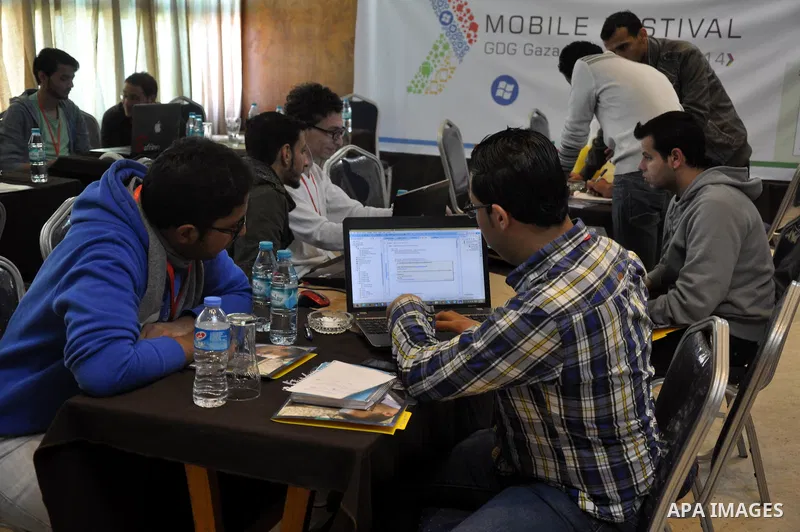 Palestinian students attend a conference of developing applications for smart phones that are running under Android operating system, in Gaza City on April 04, 2014. Students display during the meeting which was organize...