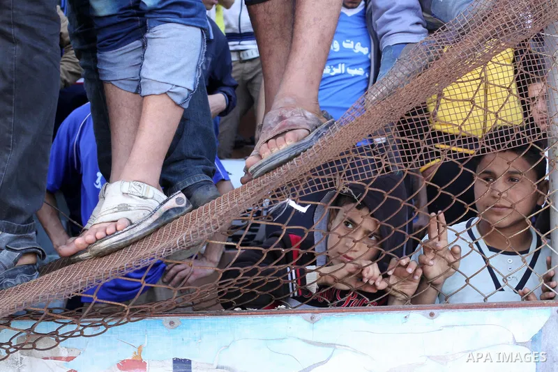 Palestinian fans of Rafah climb a fence as they watch their final soccer match against Shija'a in a local competition, at al-Yarmouk stadium in Gaza City April 11, 2014. Photo by Mohammed Asad