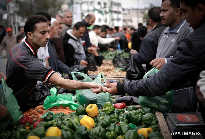Palestinians shop at the market in Gaza city, on April 11, 2014. Photo by Ezz al-Zanoon
