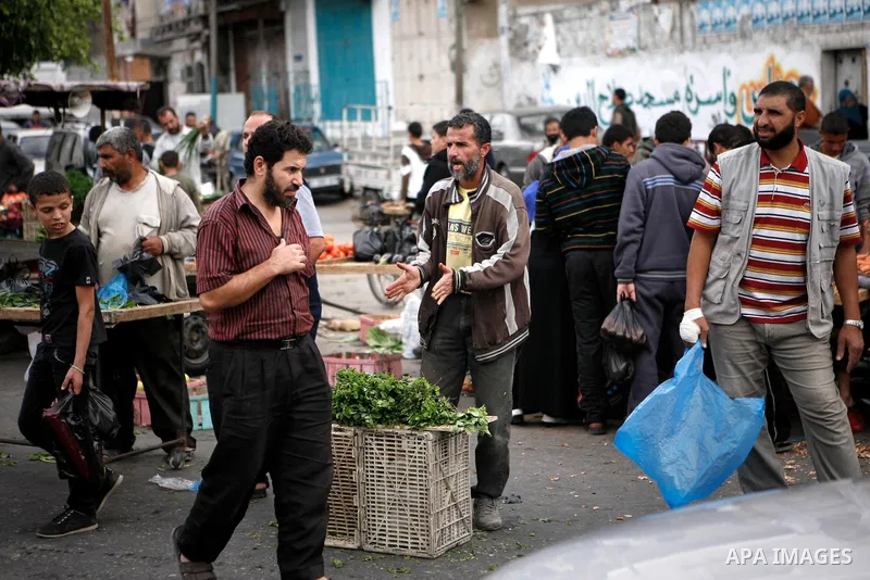 Palestinians shop at the market in Gaza city, on April 11, 2014. Photo by Ezz al-Zanoon