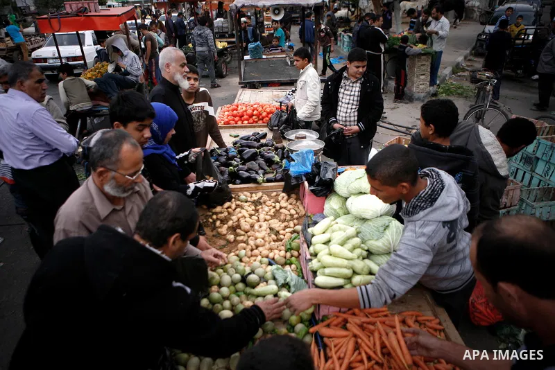 Palestinians shop at the market in Gaza city, on April 11, 2014. Photo by Ezz al-Zanoon