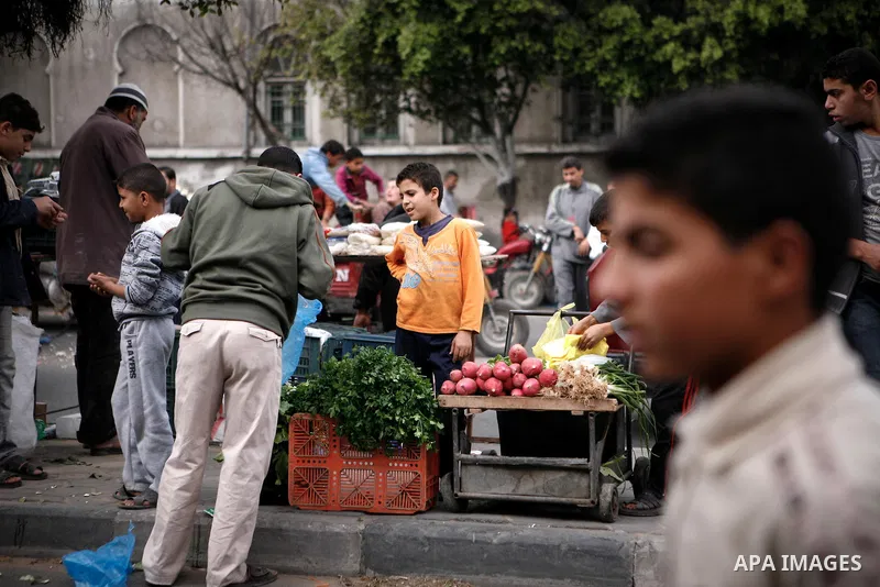 Palestinians shop at the market in Gaza city, on April 11, 2014. Photo by Ezz al-Zanoon