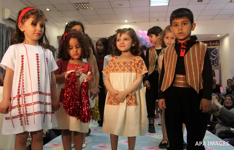 Palestinian children pose for a photograph during a children heritage fashion show, in Gaza City April 13, 2014. Photo by Mohammed Asad