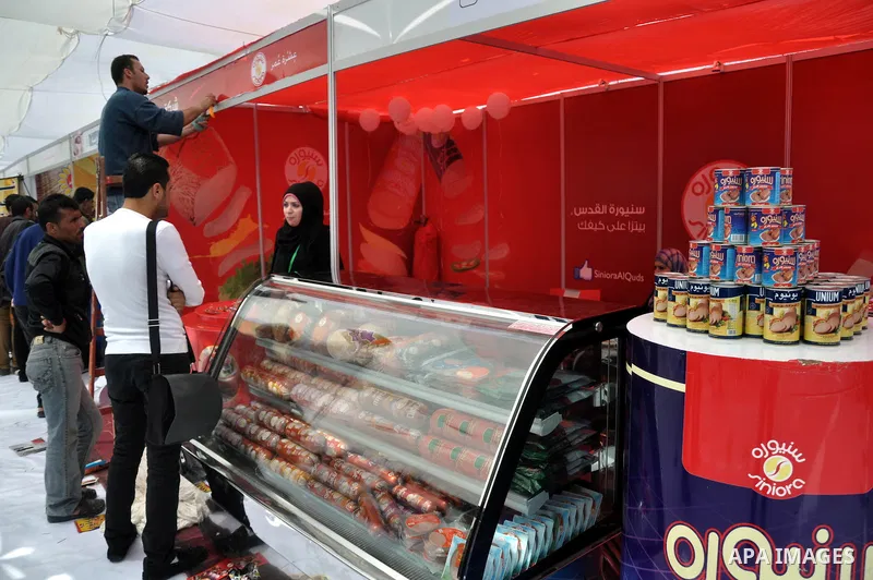 Palestinians participate in the opening of an exhibition of the national products at the Islamic University in Gaza city on April 13, 2014. Photo by Mohammed Talatene