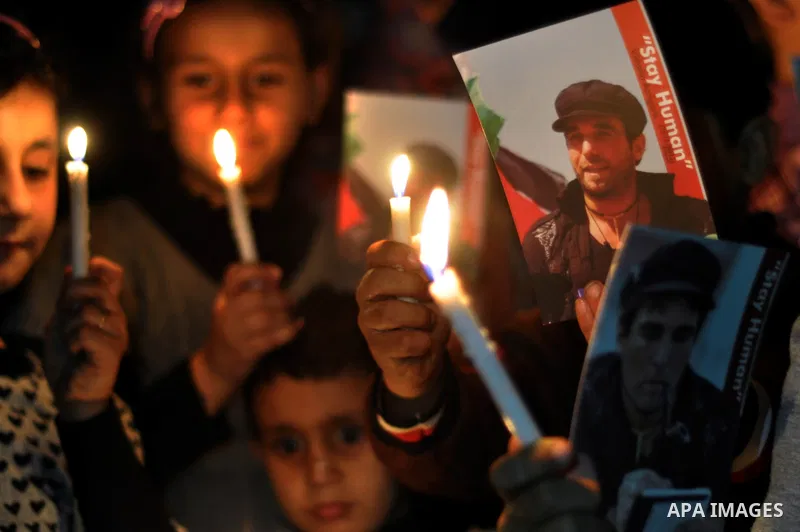 Palestinian children light candles and hold pictures of Italian human rights activist Vittorio Arrigoni during a rally marking the third anniversary of his murder, in Gaza City on April 15, 2014. Arrigoni, a 36-year-old...