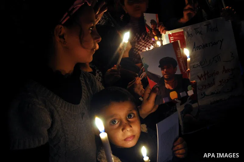 Palestinian children light candles and hold pictures of Italian human rights activist Vittorio Arrigoni during a rally marking the third anniversary of his murder, in Gaza City on April 15, 2014. Arrigoni, a 36-year-old...