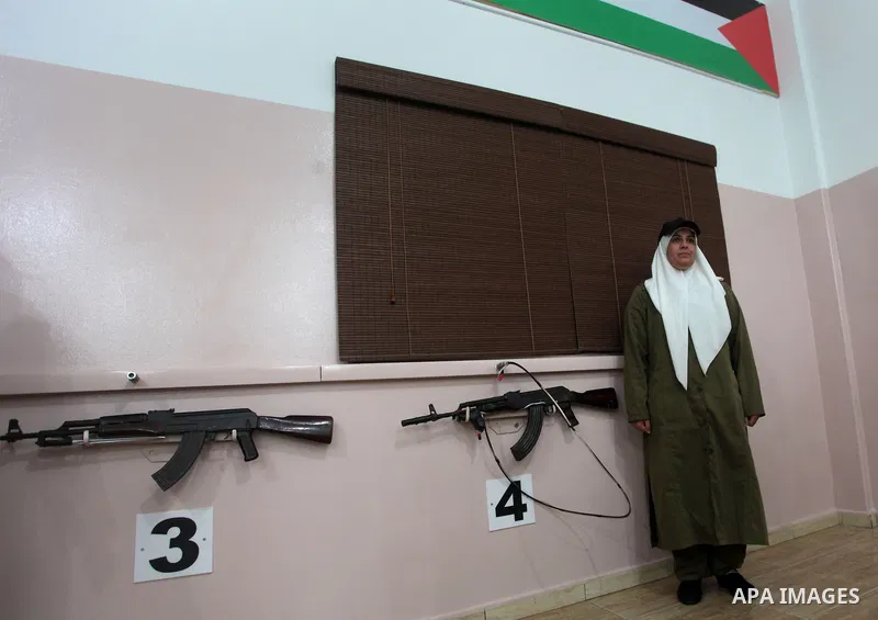 A Female member of Palestinian security forces stands during a target shooting session using makeshift laser guns at the police training headquarters in Gaza City, on April 16, 2014. Photo by Yasser Qudih