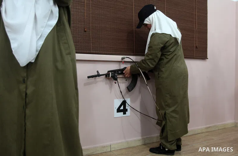 Female members of Palestinian security forces shoot during a target shooting session using makeshift laser guns at the police training headquarters in Gaza City, on April 16, 2014. Photo by Yasser Qudih