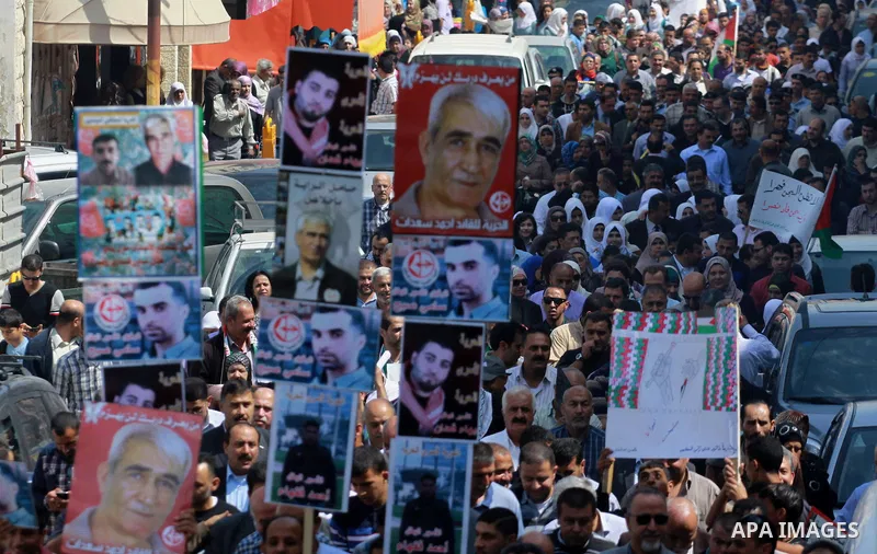 Palestinians hold pictures for the Palestinian prisoners and national flags in a rally marking Palestinian Prisoner's Day in the West Bank city of Tulkarem on April 17, 2014. Israel holds some 5,000 Palestinians it accus...