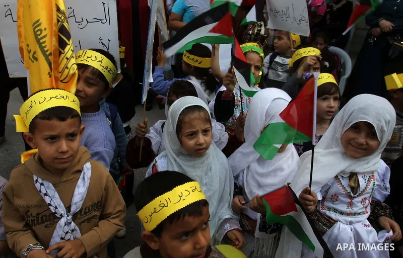 Palestinians children hold national flags in a rally marking Palestinian Prisoner's Day in the West Bank city of Tulkarem on April 17, 2014. Israel holds some 5,000 Palestinians it accuses of committing or planning viole...