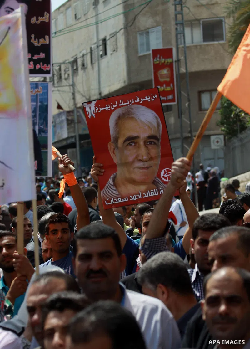 Palestinians hold pictures for the Palestinian prisoners and national flags in a rally marking Palestinian Prisoner's Day in the West Bank city of Tulkarem on April 17, 2014. Israel holds some 5,000 Palestinians it accus...