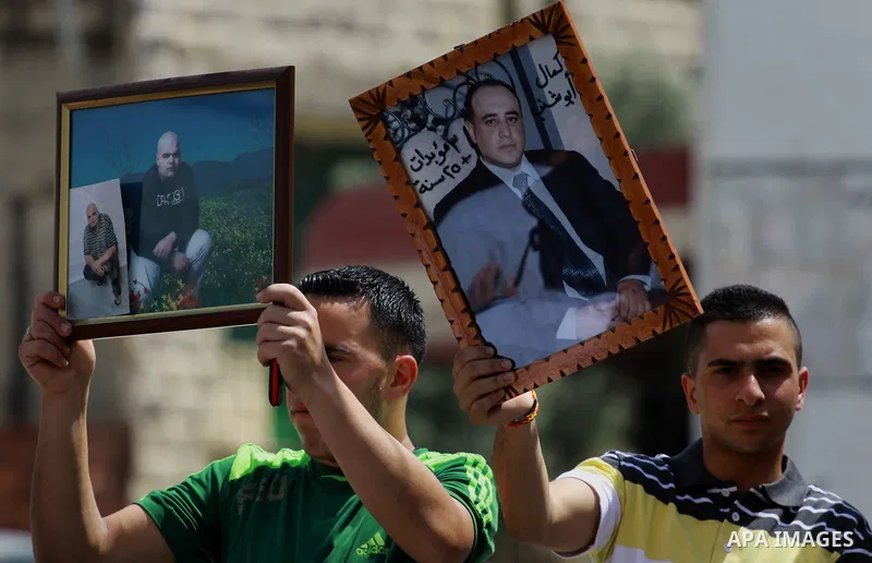 Palestinians hold pictures for the Palestinian prisoners in a rally marking Palestinian Prisoner's Day in the West Bank city of Tulkarem on April 17, 2014. Israel holds some 5,000 Palestinians it accuses of committing or...