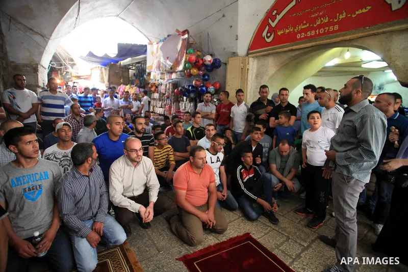 Palestinian muslims pray in front of Israeli policemen (not seen) as they prevent them from entering the Al-Aqsa mosque compound, in the Old City of Jerusalem on April 18, 2014. Israeli authorities on Friday prevented Pa...