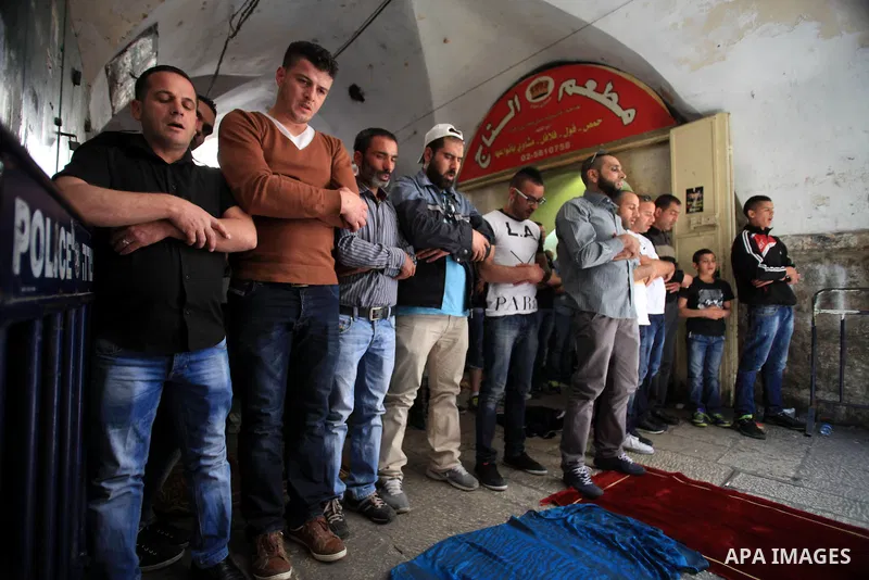 Palestinian muslims pray in front of Israeli policemen (not seen) as they prevent them from entering the Al-Aqsa mosque compound, in the Old City of Jerusalem on April 18, 2014. Israeli authorities on Friday prevented Pa...