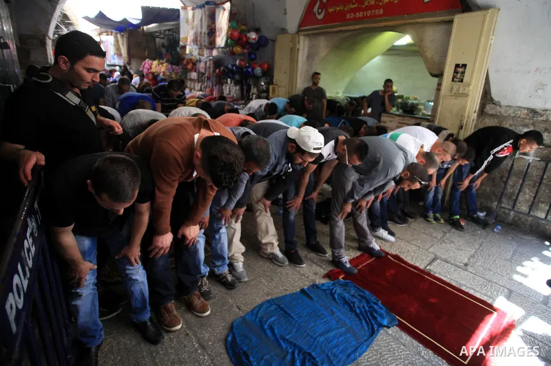 Palestinian muslims pray in front of Israeli policemen (not seen) as they prevent them from entering the Al-Aqsa mosque compound, in the Old City of Jerusalem on April 18, 2014. Israeli authorities on Friday prevented Pa...