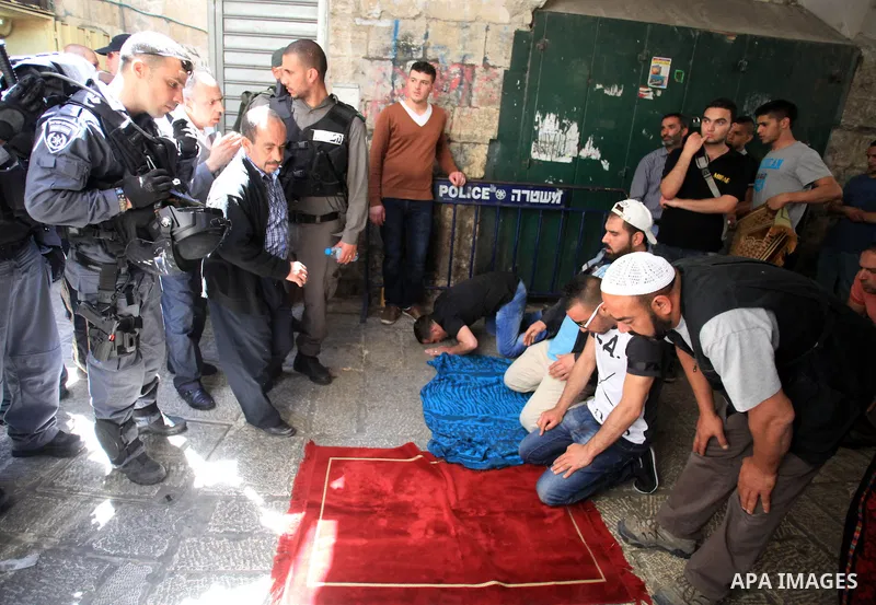 Palestinian muslims pray in front of Israeli policemen as they prevent them from entering the Al-Aqsa mosque compound, in the Old City of Jerusalem on April 18, 2014. Israeli authorities on Friday prevented Palestinians,...