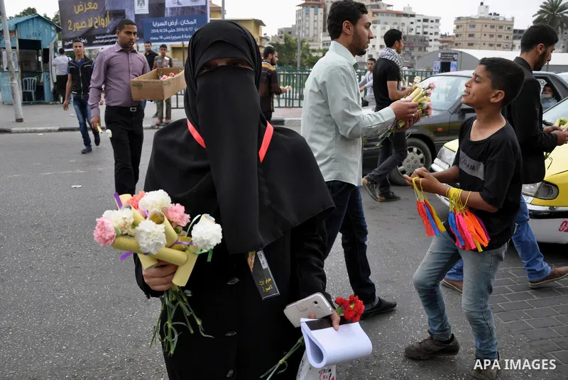 Palestinian youths distribute roses and pictures of Palestinian prisoners to mark the Palestinian Prisoner Day in Gaza City April 19, 2014. Photo by Mohammed Talatene