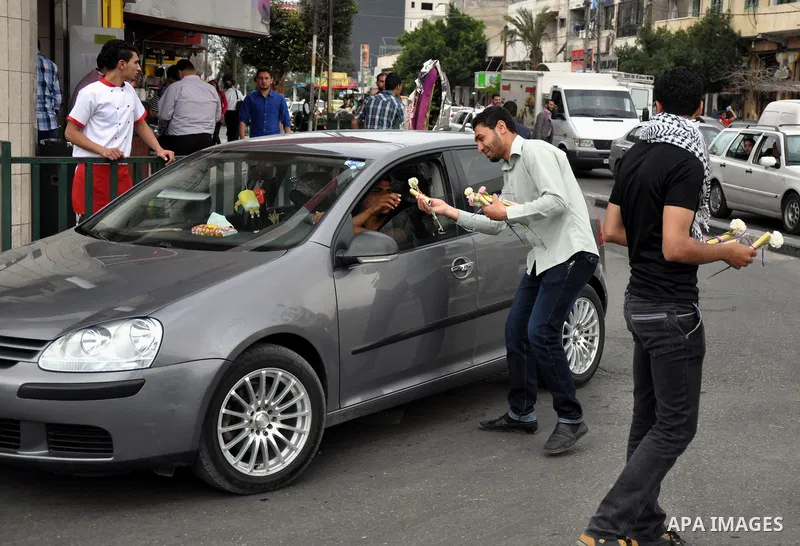 Palestinian youths distribute roses and pictures of Palestinian prisoners to mark the Palestinian Prisoner Day in Gaza City April 19, 2014. Photo by Mohammed Talatene