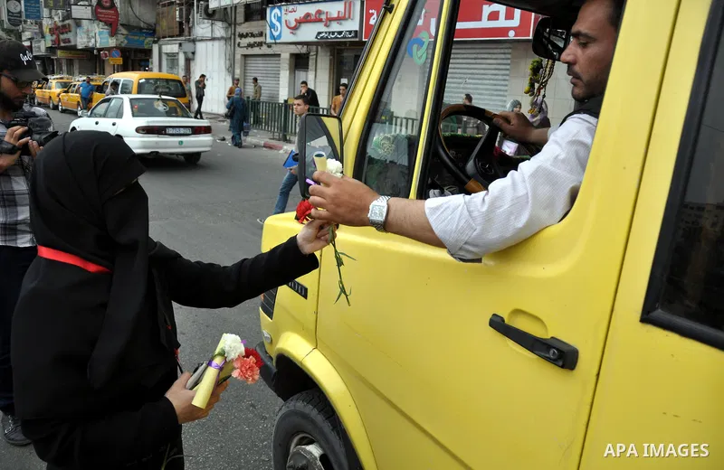 Palestinian youths distribute roses and pictures of Palestinian prisoners to mark the Palestinian Prisoner Day in Gaza City April 19, 2014. Photo by Mohammed Talatene