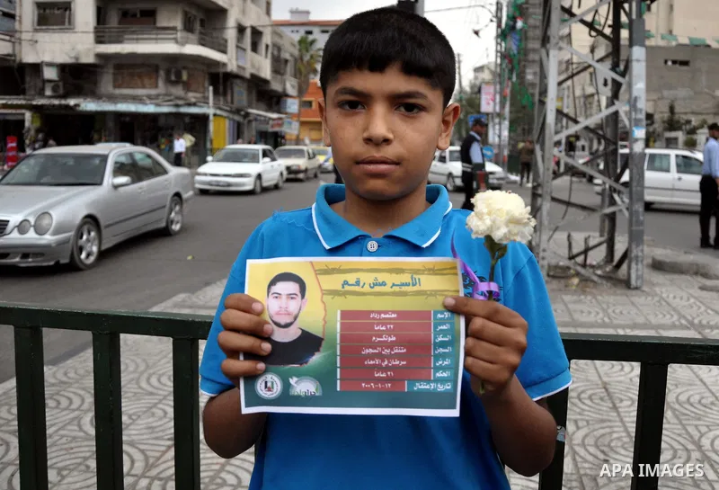 Palestinian youths distribute roses and pictures of Palestinian prisoners to mark the Palestinian Prisoner Day in Gaza City April 19, 2014. Photo by Mohammed Talatene