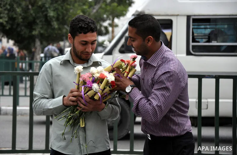 Palestinian youths distribute roses and pictures of Palestinian prisoners to mark the Palestinian Prisoner Day in Gaza City April 19, 2014. Photo by Mohammed Talatene