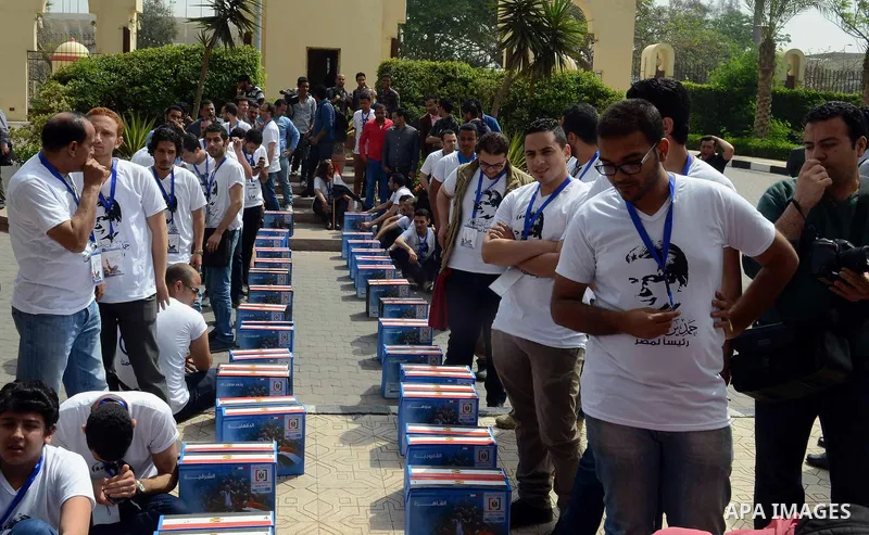 Campaign volunteers of presidential hopeful Hamdeen Sabahi, carry boxes containing thousands of endorsements at the election commission office in Cairo, Egypt, Saturday, April 19, 2014. It is mandatory for any presidenti...