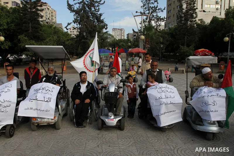 Palestinians with special needs take part in celebrate the agreement to form a unity government in Gaza city on April 24, 2014. The agreement was reached on April 23, in talks in Gaza City which continued into the early...