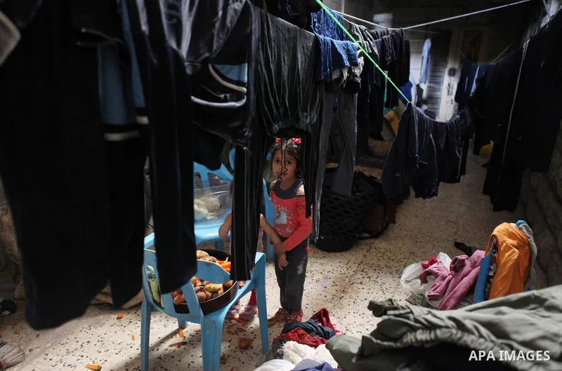 A Palestinian girl plays inside her house in Kafr near the West Bank city of Ramallah April 25, 2014. Al-Kurdi poor family consist of 8 members who face difficult life and the high cost of living. Photo by Shadi Hatem