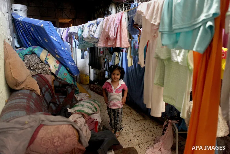A Palestinian girl plays inside her house in Kafr near the West Bank city of Ramallah April 25, 2014. Al-Kurdi poor family consist of 8 members who face difficult life and the high cost of living. Photo by Shadi Hatem