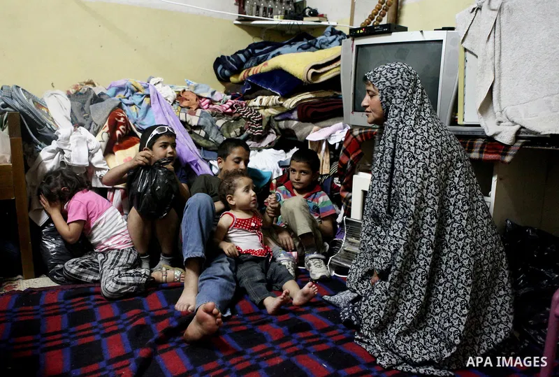 A Palestinian woman with her children inside thier house in Kafr near the West Bank city of Ramallah on April 25, 2014. Al-Kurdi poor family consist of 8 members who face difficult life and the high cost of living. Photo...