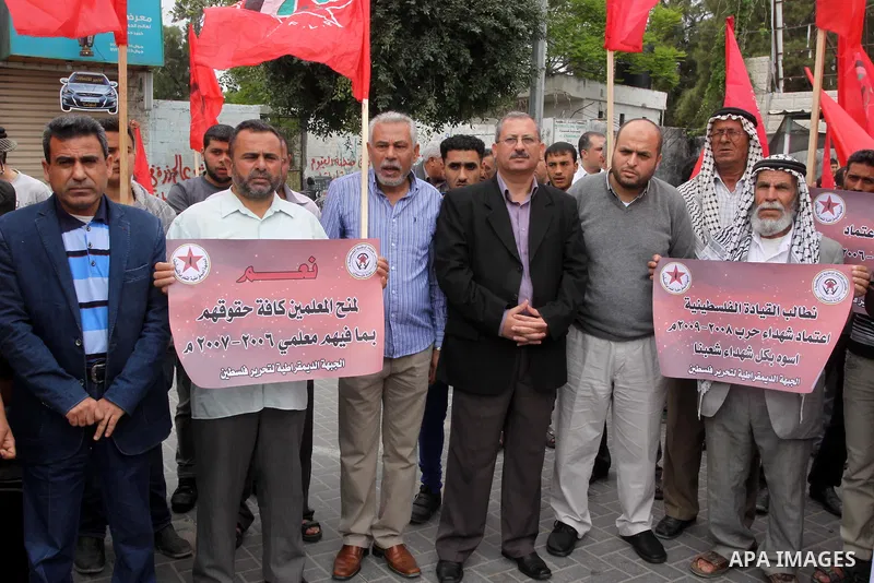 Supporters of Democratic Front for the Liberation of Palestine shout slogans as they take part in a demonstration in support of a new attempt to reconcile the militant Islamist movement Hamas and its Palestine Liberation...