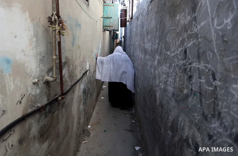 A Palestinian woman walks outside her house at Shati refugee camp, in Gaza City on April 27, 2014. The Israeli prime minister, Binyamin Netanyahu, accused the western-backed Palestinian president, Mahmoud Abbas, of formi...