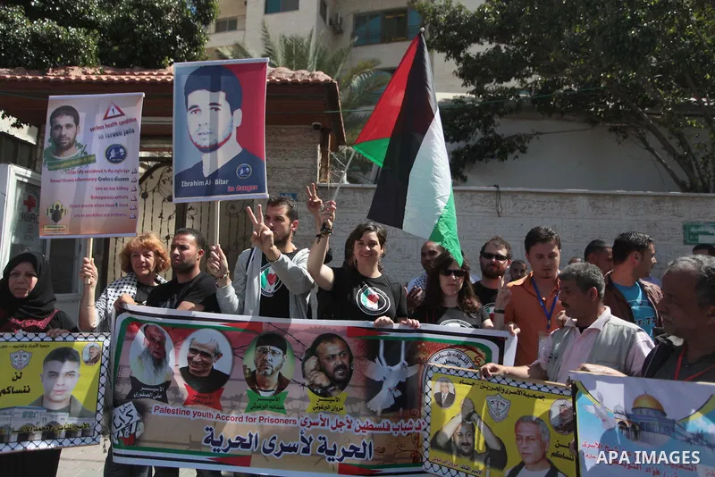 Palestinians with Spanish delegation take part in a protest demanding the release of their relatives prisoners held in Israeli jails, in front of the Red Cross office in Gaza City, on April 28, 2014. Photo by Ashraf Amra