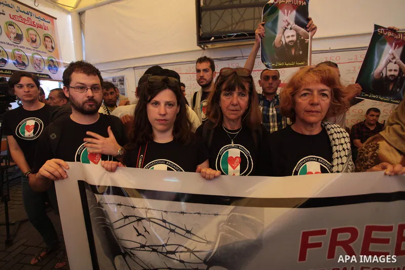 Palestinians with Spanish delegation take part in a protest demanding the release of their relatives prisoners held in Israeli jails, in front of the Red Cross office in Gaza City, on April 28, 2014. Photo by Ashraf Amra