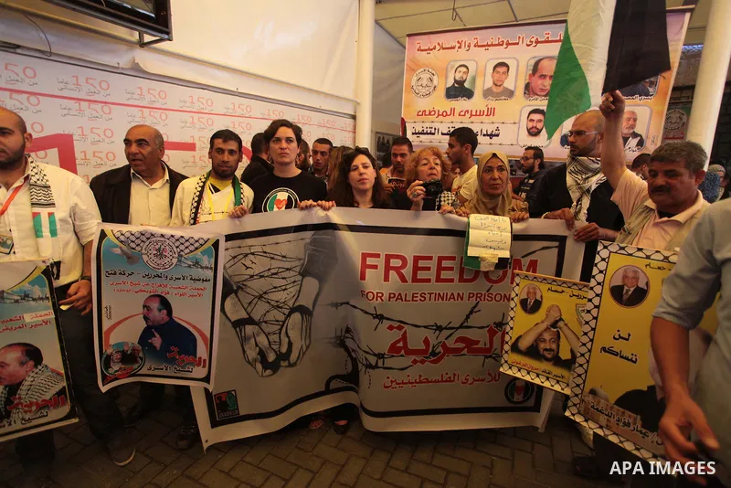 Palestinians with Spanish delegation take part in a protest demanding the release of their relatives prisoners held in Israeli jails, in front of the Red Cross office in Gaza City, on April 28, 2014. Photo by Ashraf Amra