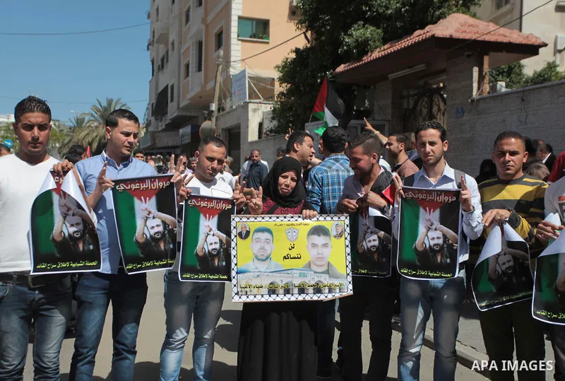 Palestinians with Spanish delegation take part in a protest demanding the release of their relatives prisoners held in Israeli jails, in front of the Red Cross office in Gaza City, on April 28, 2014. Photo by Ashraf Amra