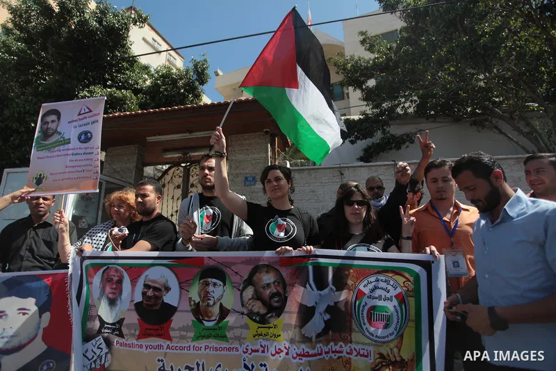 Palestinians with Spanish delegation take part in a protest demanding the release of their relatives prisoners held in Israeli jails, in front of the Red Cross office in Gaza City, on April 28, 2014. Photo by Ashraf Amra
