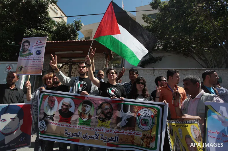 Palestinians with Spanish delegation take part in a protest demanding the release of their relatives prisoners held in Israeli jails, in front of the Red Cross office in Gaza City, on April 28, 2014. Photo by Ashraf Amra
