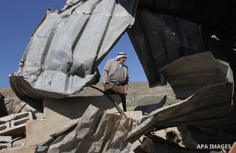 A Palestinian man inspects the remains of a mosque after it was demolished by Israeli authorities who said it was built without municipal permission on April 29, 2014 in the West Bank village of Khirbet al-Tawil, south o...