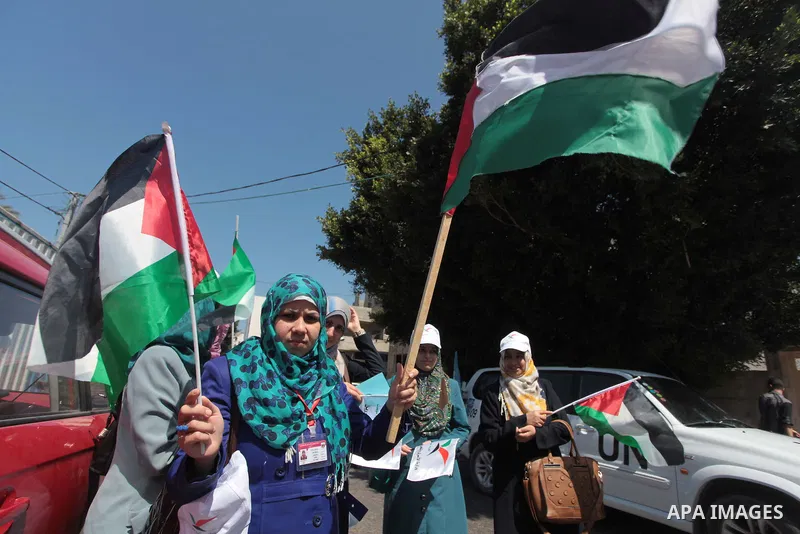 Palestinians hold Palestine flags during a protest against administrative detention of Palestinian prisoners In Israeli jails, in front of the United Nations Development Programme office (UNDP) in Gaza City on April 29,...